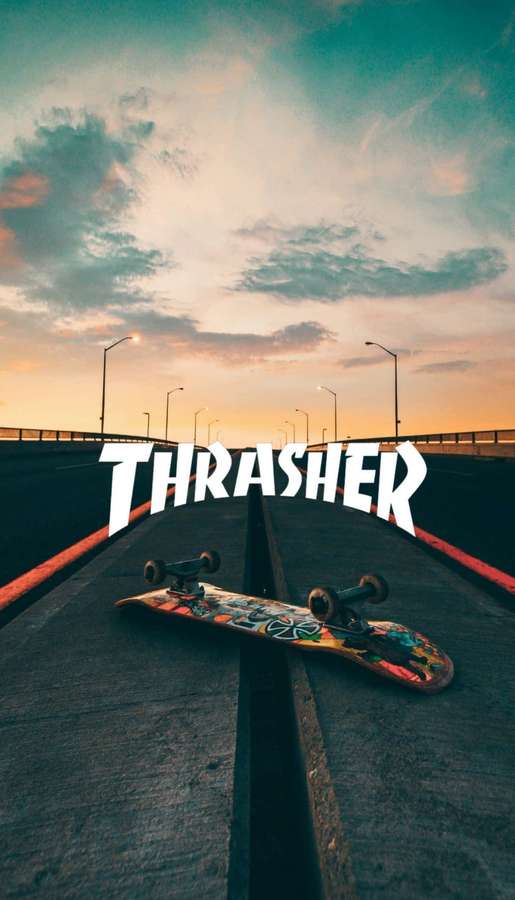 Skateboard med färgglada grafik liggande på en bro vid solnedgång med Thrasher-logotyp. — Hype Aesthetic Bakgrundsbilder