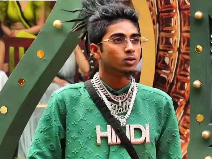 Junger Mann in grünem Marken-Sweatshirt mit 'HINDI' und mehreren Halsketten. — Hypebeast Bilder