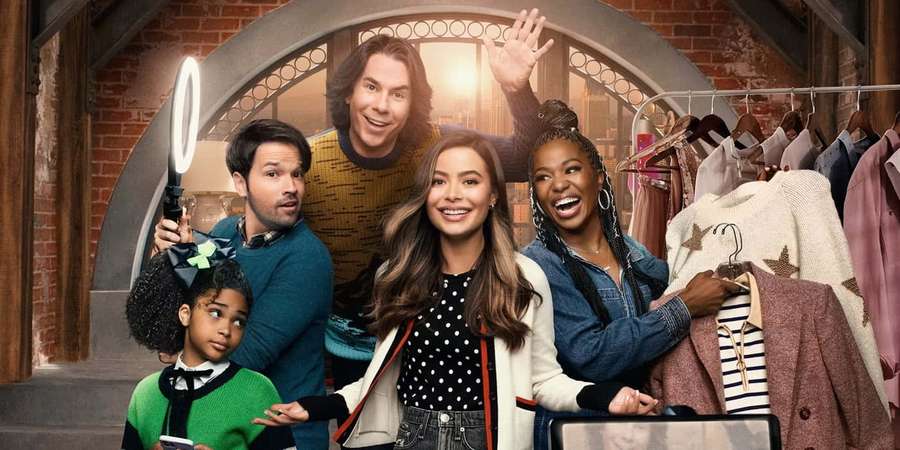 A diverse family of five happily posing in a clothing store with racks and a ring light. — Icarly Wallpaper