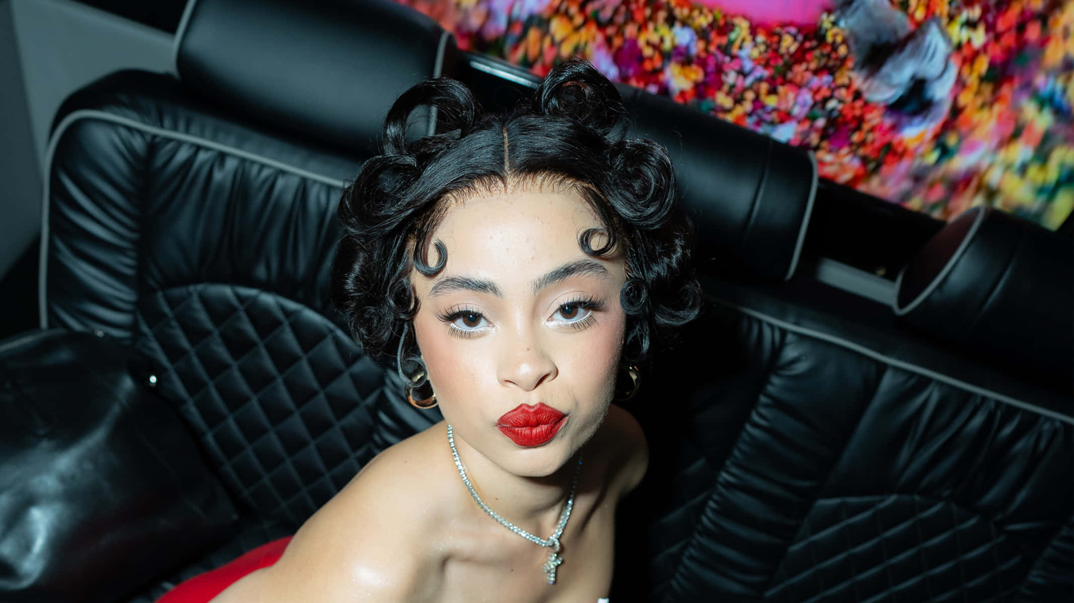 Mujer con labios rojos y rizos vintage en un sofá de cuero negro. — Ice Spice Fondos de pantalla