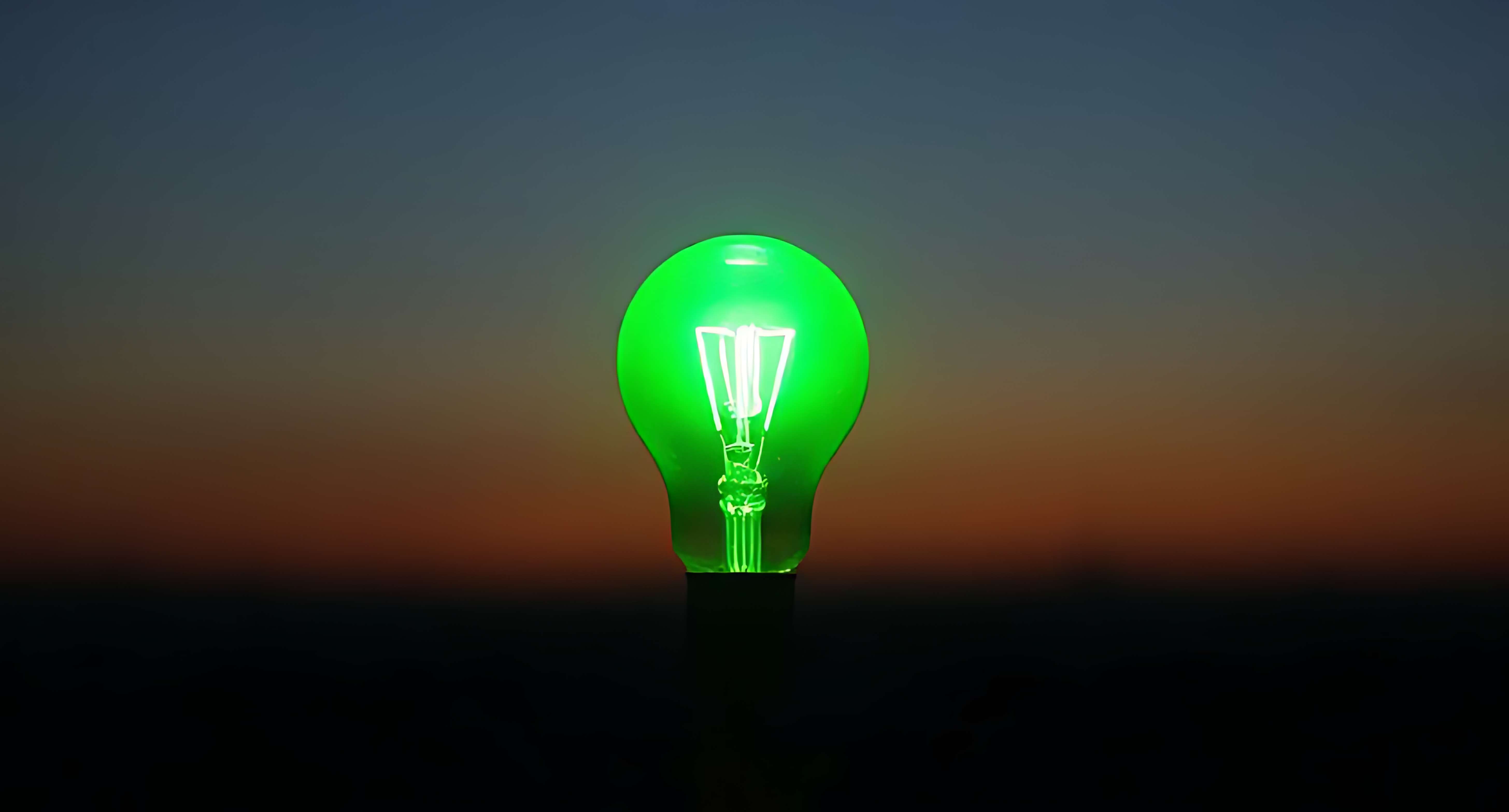 A glowing green light bulb against a twilight sky. — Idea PNG