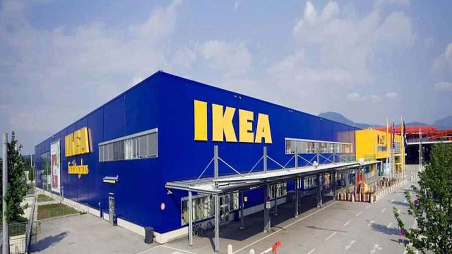 Blue IKEA store building with yellow logo and parking lot under clear sky. — Ikea Background