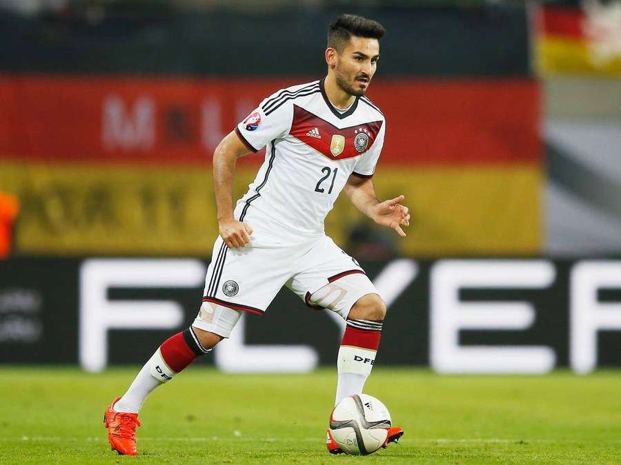 German soccer player number 21 dribbling a ball on a grass field at night. — Ilkay Gundogan Wallpaper