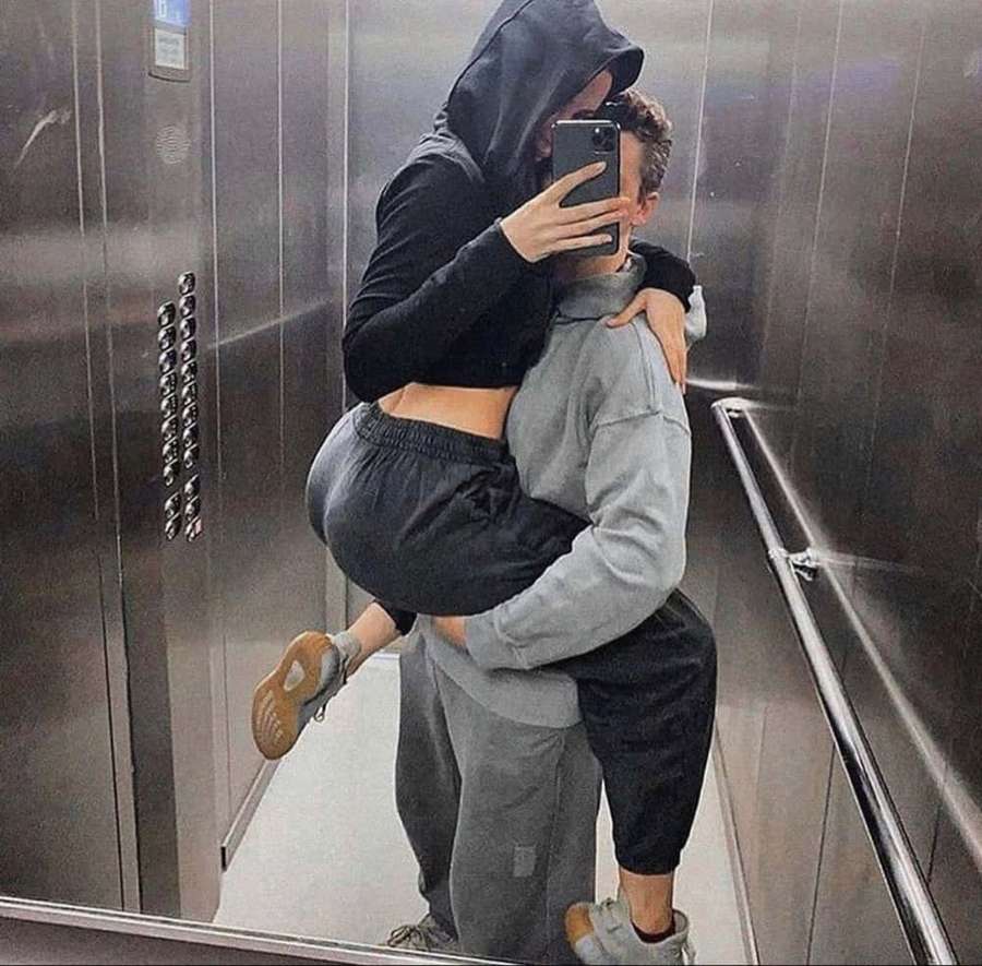 Una pareja se abraza en un ascensor mientras uno se toma una selfie en el espejo. — Imágenes de ascensor Imágenes