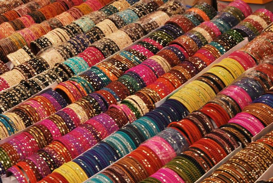 Filas de pulseras coloridas con lentejuelas exhibidas para la venta en un mercado. — Imágenes de Bangles Imágenes