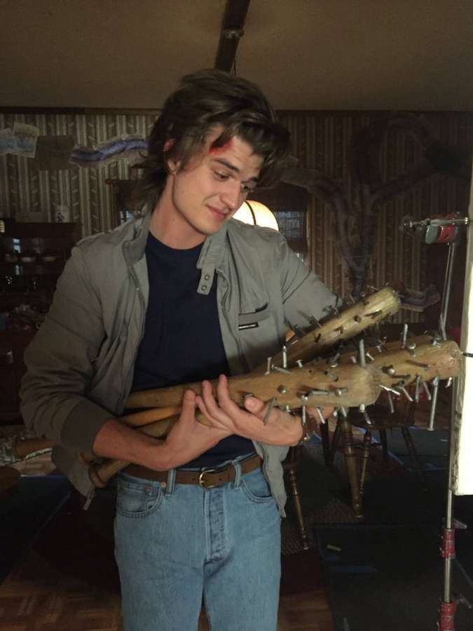 Joven sosteniendo un garrote de madera con clavos en interiores con una marca roja en la frente. — Imágenes de Cast Fondos de pantalla