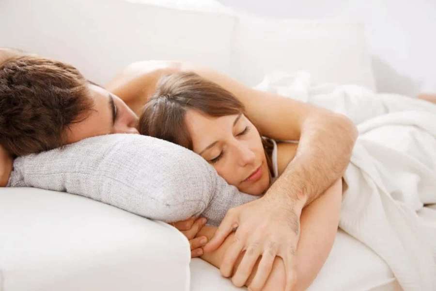 Una pareja durmiendo juntos en la cama envueltos en sábanas blancas. — Imágenes de Sofá Imágenes