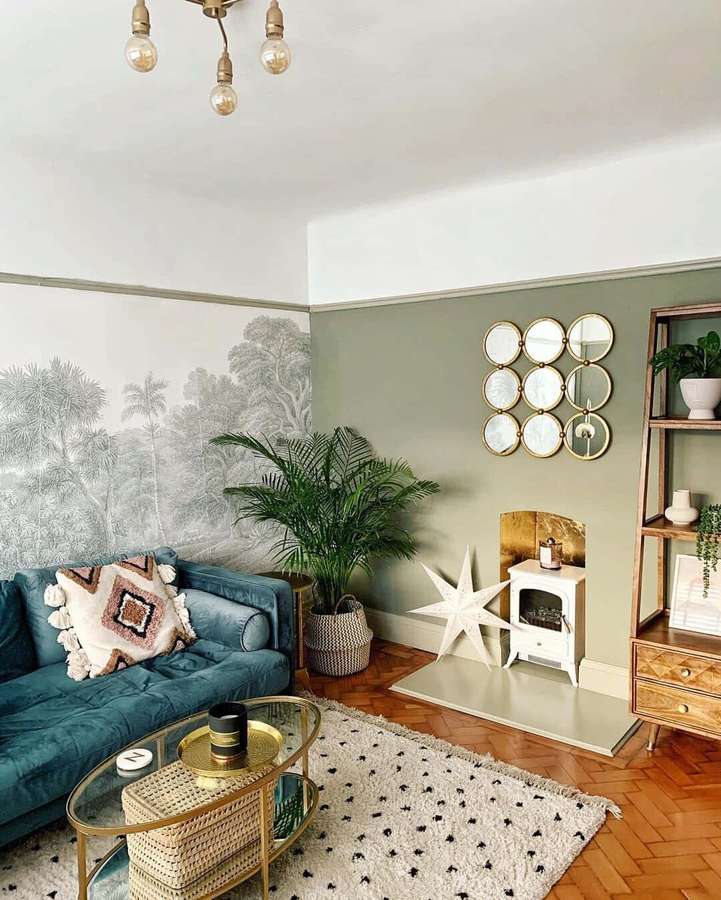 Sala de estar aconchegante com sofá azul-petróleo, papel de parede de palmeira e detalhes dourados. — Imagens do sofá Fotos