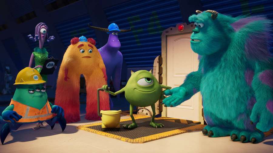 Monsters Inc. characters in a factory setting with Sulley and Mike shaking hands. — Inc Wallpaper