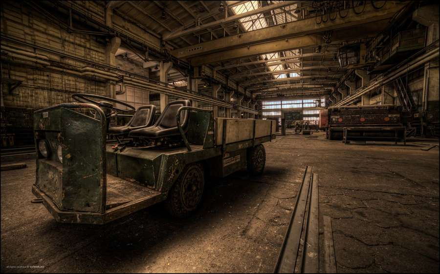 Abandoned green industrial vehicle in a decaying factory interior. — Industrial Background