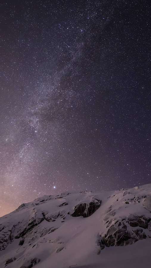 Verschneiter Berggipfel unter einem sternenklaren Nachthimmel mit sichtbarer Milchstraße. — iOS 8 Bilder