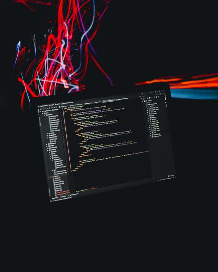 Laptop-Bildschirm mit Code und farbenfrohen Lichtspuren im Hintergrund. — iPhone Codieren Wallpaper