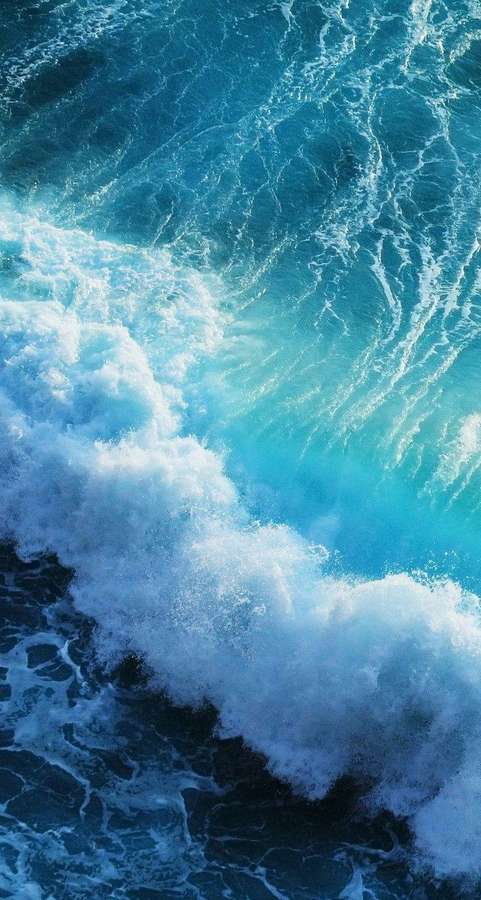 Eine brechende Meereswelle mit weißem Schaum und tiefblauem Wasser. — iPhone Live Bilder