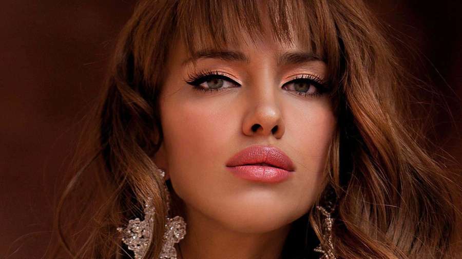 Close-up of a woman with brown hair and glittery earrings. — Irina shayk Wallpaper