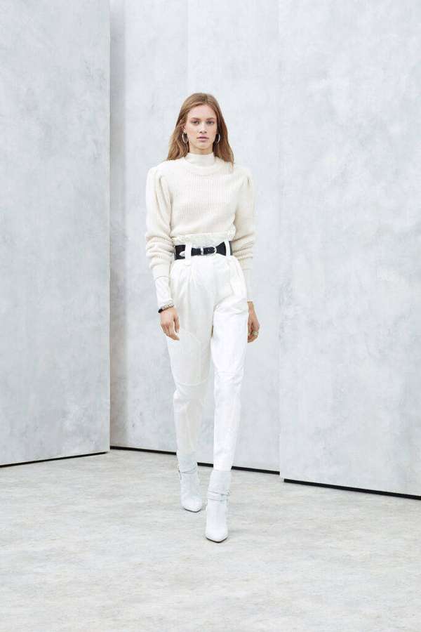 Woman in white outfit with black belt standing in minimalist concrete room. — Iro Wallpaper