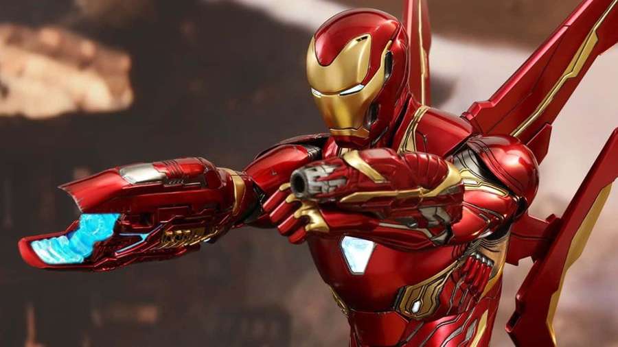 Iron Man in red gold armor firing repulsor blasts with glowing blue energy. — Iron Man Action Figures Wallpaper