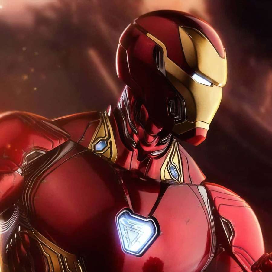 Iron Man in red and gold armor with glowing arc reactor against fiery background. — Iron Man Tablet Wallpaper