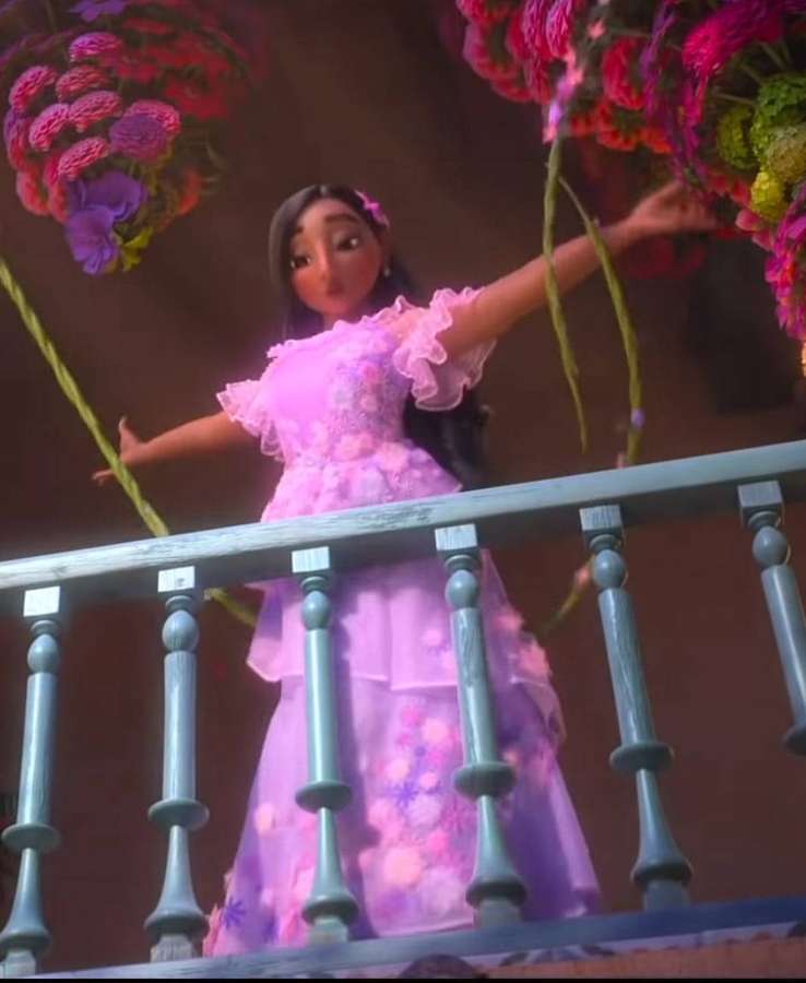 Ein Mädchen in einem rosa Kleid auf einem Balkon, umgeben von bunten hängenden Blumen. — Isabela Bilder