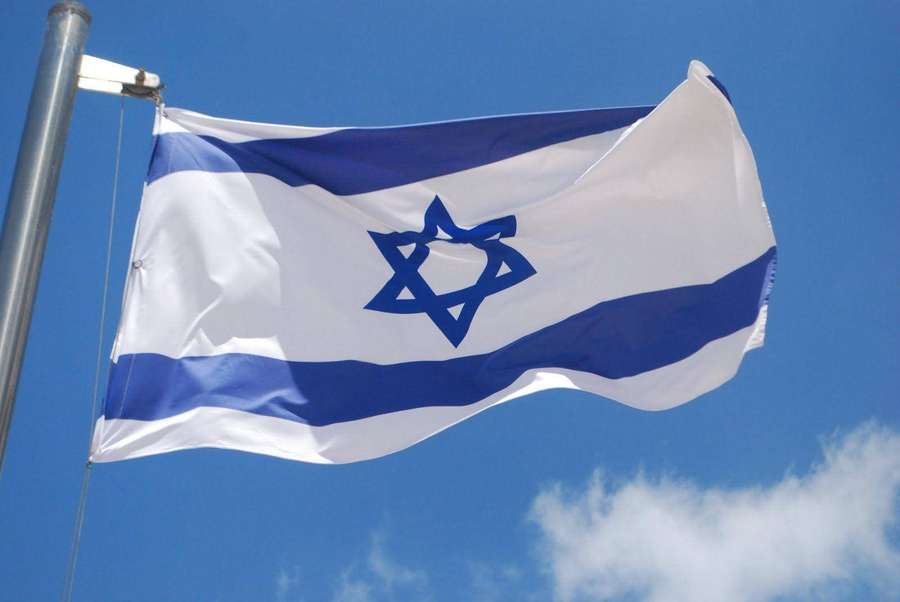 Israeli flag waving in the wind against a blue sky with clouds — Israel Flag Wallpaper