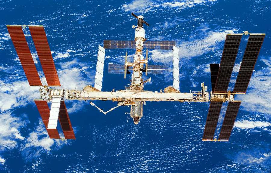 International Space Station floating above Earth with solar panels deployed. — Iss Wallpaper