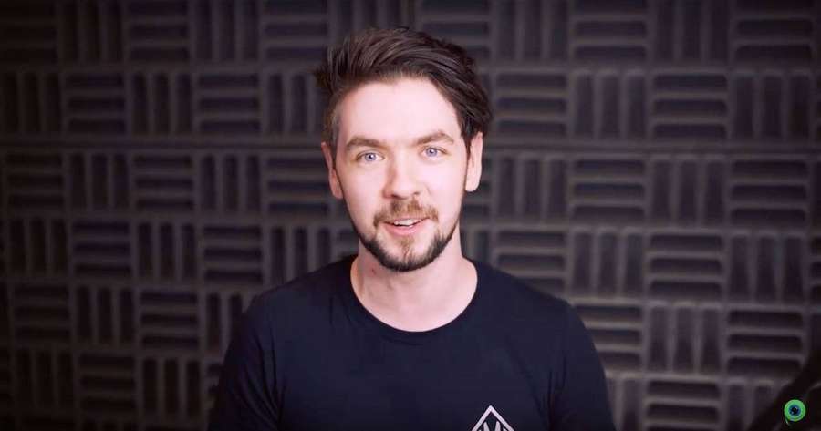 Hombre con ojos azules y barba sonriendo frente a una pared acústica. — Jacksepticeye Fondos de pantalla