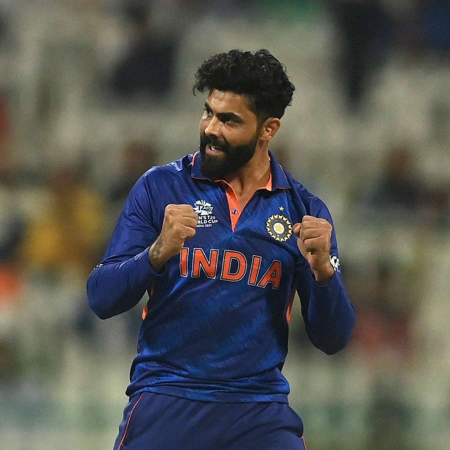 Indian cricket player celebrating victory with fists raised at night game. — Jadeja Wallpaper