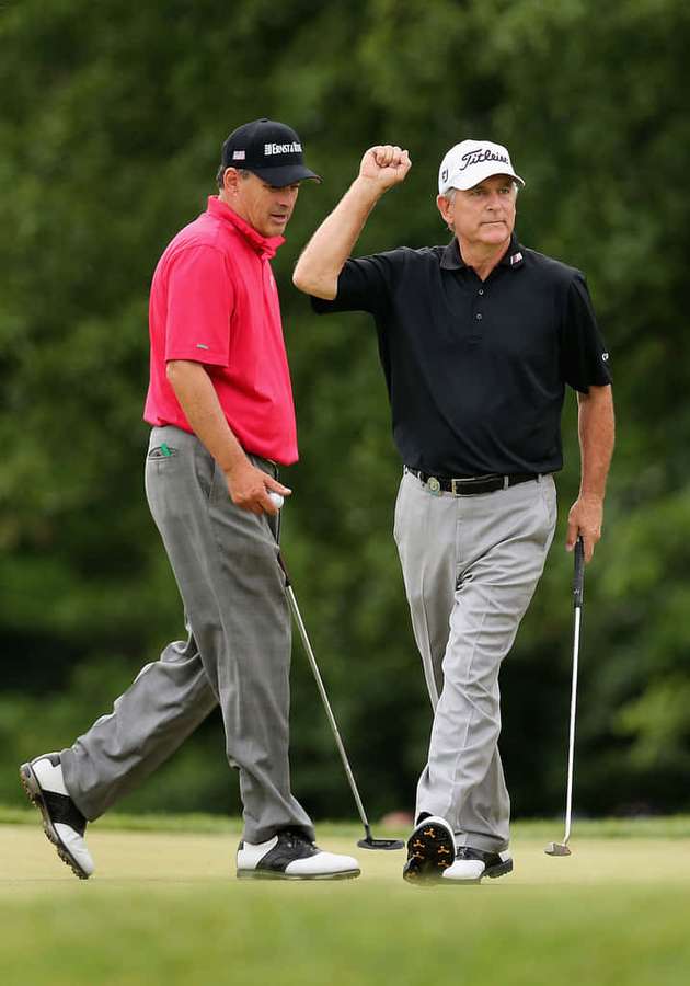 Two male golfers celebrate on a green golf course with one raising his fist. — Jay Haas Picture