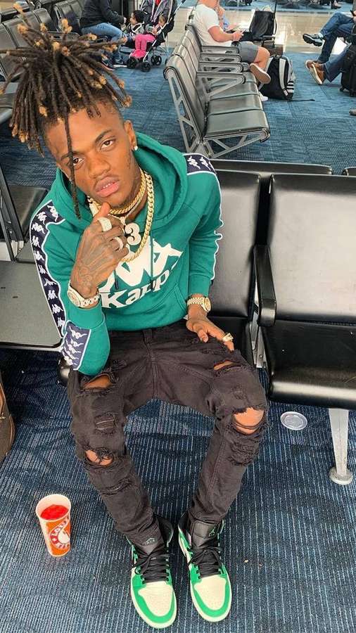 Junger Mann mit Dreadlocks im Flughafenterminal, trägt grünen Hoodie und zerrissene Jeans. — Jayda Youngan Wallpaper