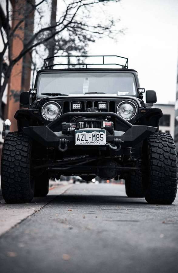 Jeep Wrangler preto com placa do Colorado estacionado em rua da cidade. — Jeep preto Papéis de Parede