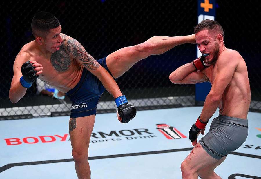 Two male fighters in a cage one delivering a high kick to the other. — Jeff Molina Wallpaper
