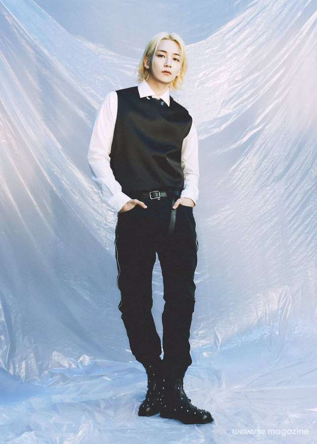 Person in black vest and pants standing against blue plastic backdrop. — Jeonghan Wallpaper