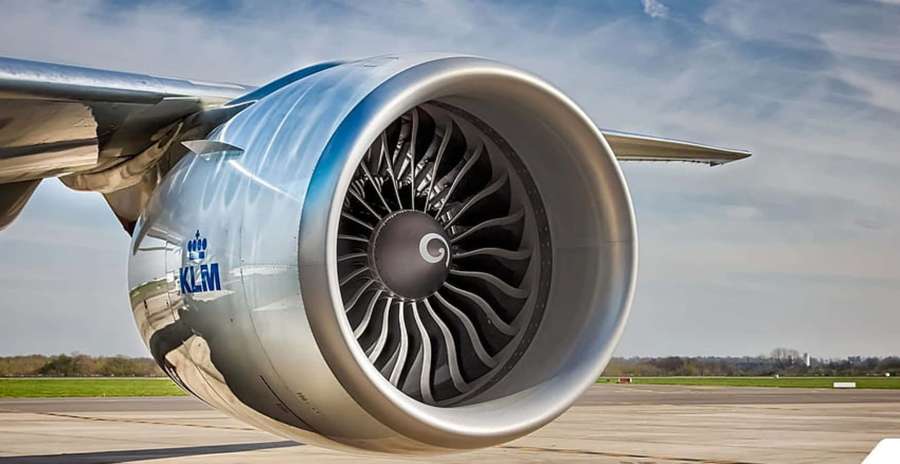 KLM airplane engine on runway with cloudy sky and distant trees. — Jet Engine Wallpaper