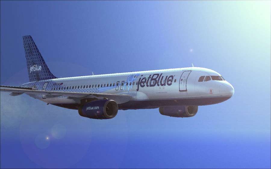 Aereo JetBlue in volo nel cielo azzurro con bagliori dell'obiettivo — Jetblue Sfondi