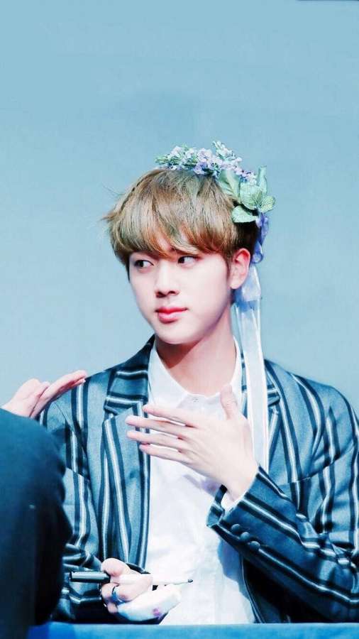 Nuori mies kukkapäähineessä allekirjoittaa nimikirjoituksia raidallisessa bleiserissä. — Jin Bts Cute Taustakuvat
