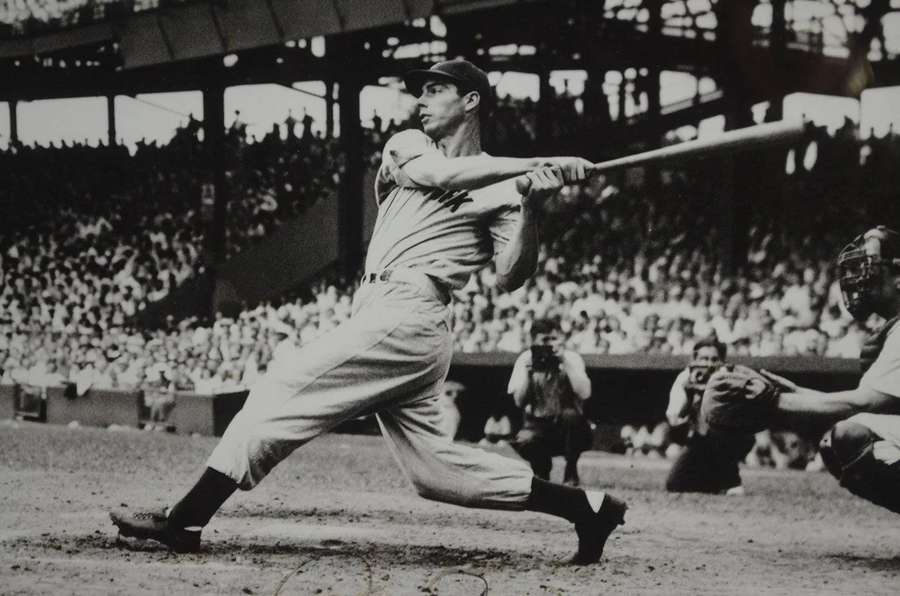 Baseball player swinging bat during game with crowd in background — Joe Dimaggio Wallpaper