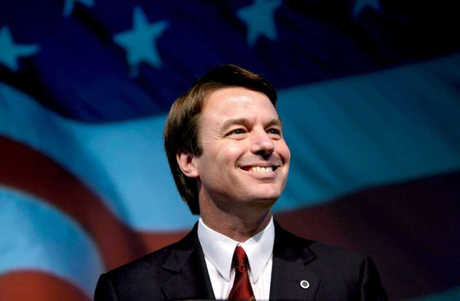 Man in suit and red tie smiling in front of American flag. — John Edwards Wallpaper