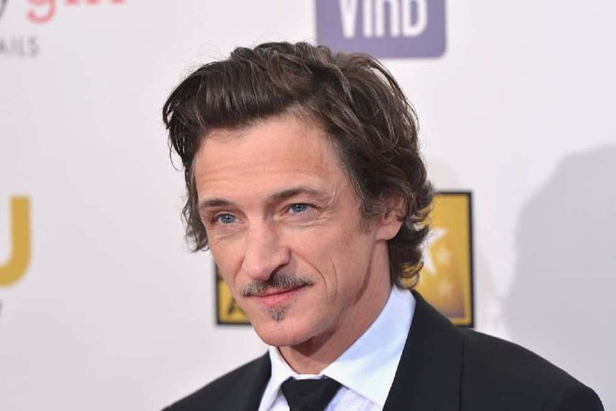 Actor Johnny Depp in a black suit and tie at a red carpet event. — John Hawkes Wallpaper