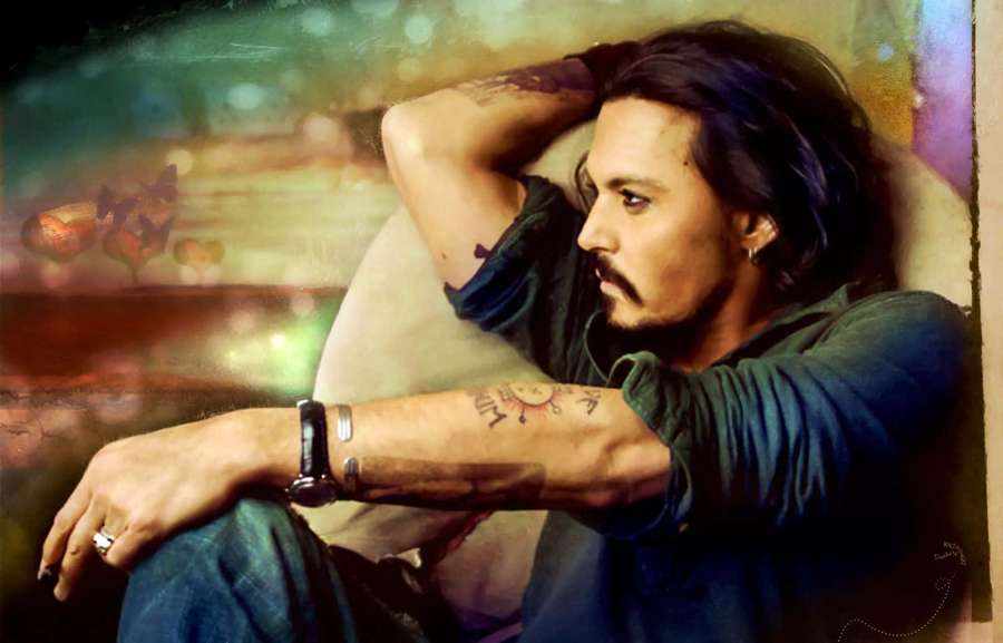 Ein tätowierter Mann sitzt nachdenklich in einem Stuhl mit einem farbenfrohen abstrakten Hintergrund. — Johnny Depp Bilder