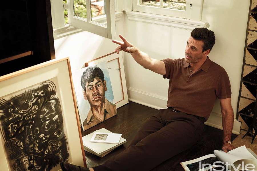 Man sitting on floor surrounded by art and books near window — Jon Hamm Wallpaper