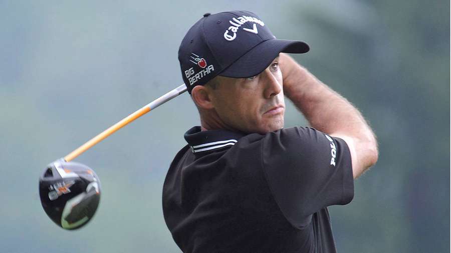 Professional golfer mid-swing on a green course — Jonathan Byrd Wallpaper