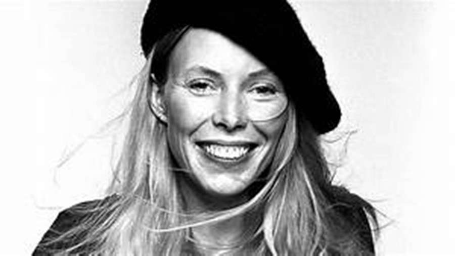 Una donna sorridente con capelli biondi che indossa un berretto nero in un ritratto in studio. — Joni Mitchell Sfondi