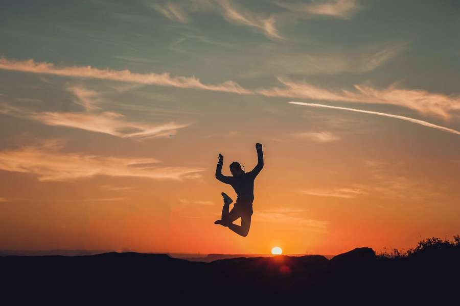 Person jumping in silhouette against a sunset sky — Jumping Background