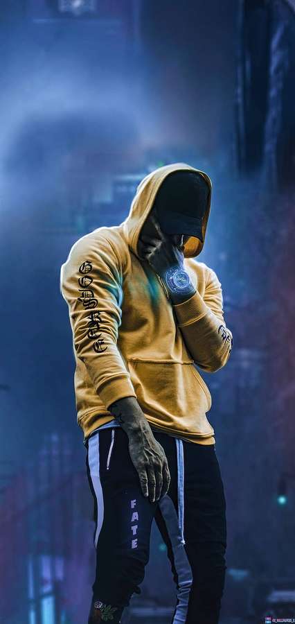 Ein maskierter Rapper in einem gelben Hoodie tritt mit einem glühenden Mikrofon in einer verrauchten Stadt bei Nacht auf. — Jungs Wallpaper