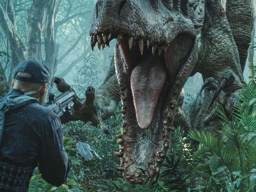 Mann mit Gewehr steht einem riesigen brüllenden Dinosaurier im dichten Dschungel gegenüber. — Jurassic World Bilder