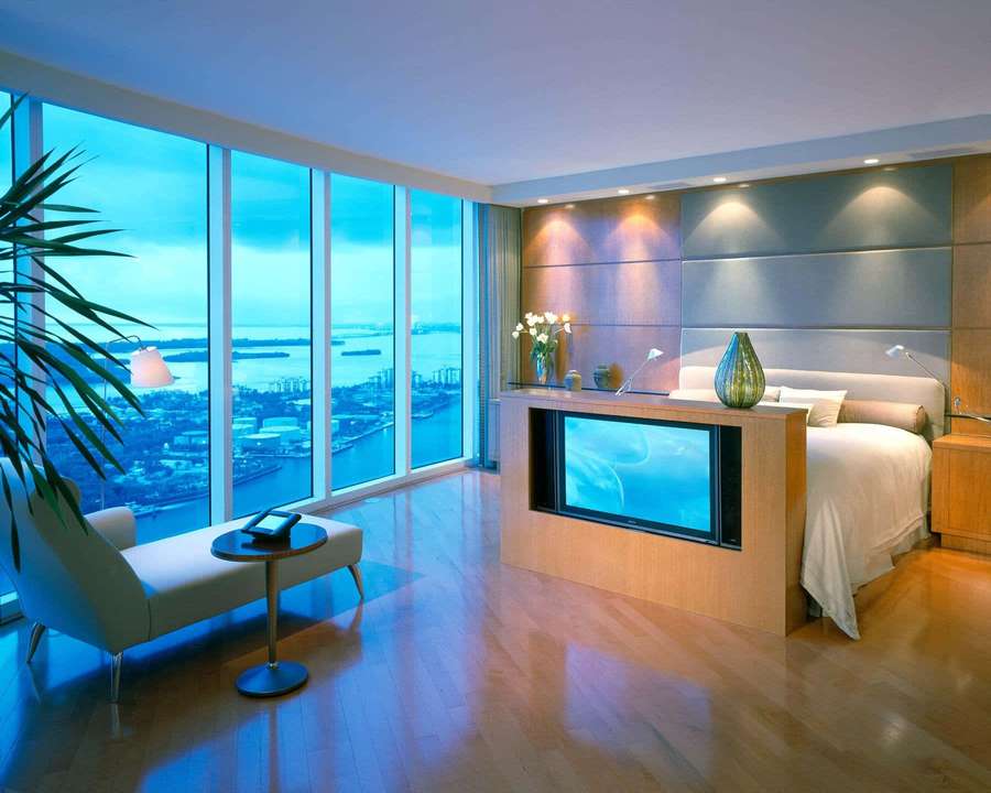 Kamar tidur mewah modern dengan pemandangan kota panorama melalui jendela besar saat senja. — Kamar Hotel Wallpaper