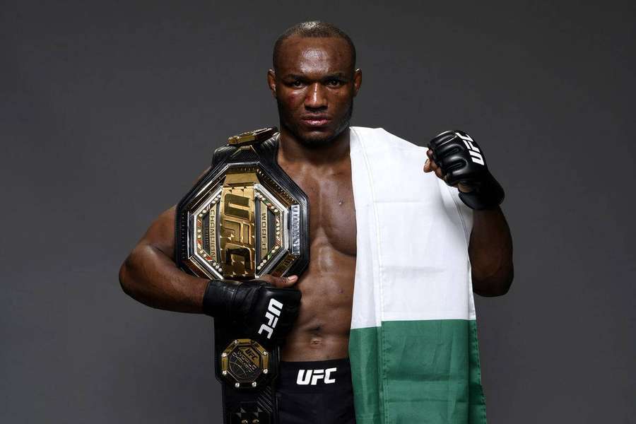 UFC champion holding belt draped in Nigerian flag in studio — Kamaru Usman Background