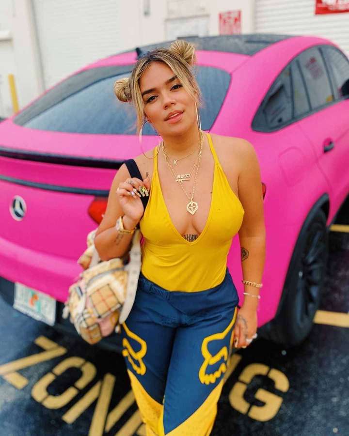 Woman in yellow top and blue pants posing next to pink car. — Karol Wallpaper