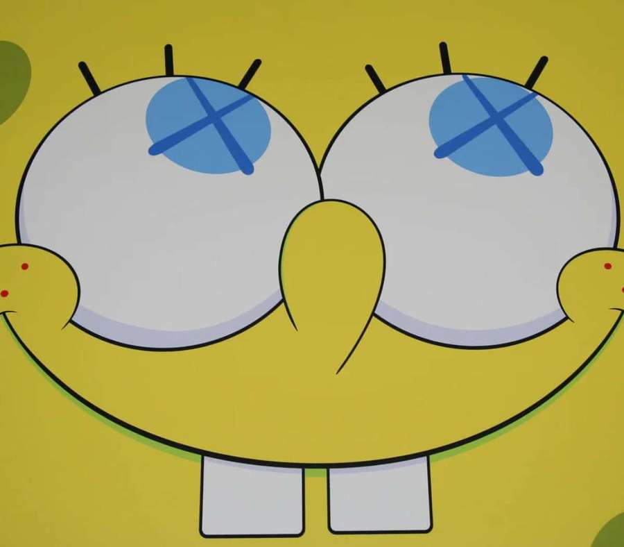 SpongeBob SquarePants with wide eyes and blue X's over them smiling brightly. — Kaws Spongebob Wallpaper