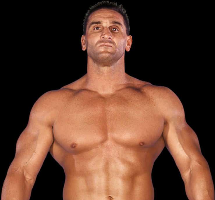 A muscular man with defined abs and arms standing against a black background. — Ken Shamrock Background