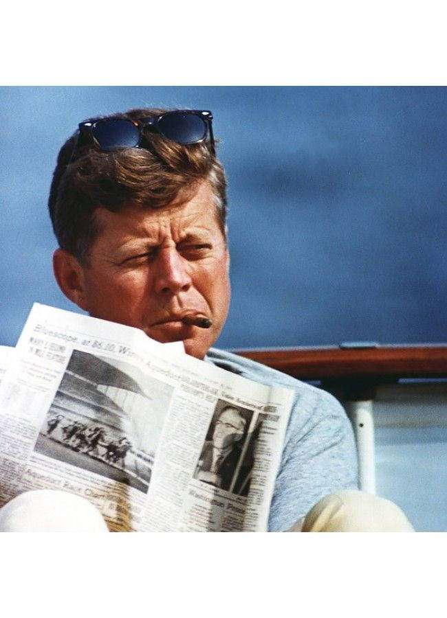 John F Kennedy liest Zeitung auf Boot mit Zigarre und Sonnenbrille auf dem Kopf — Kennedy Bilder